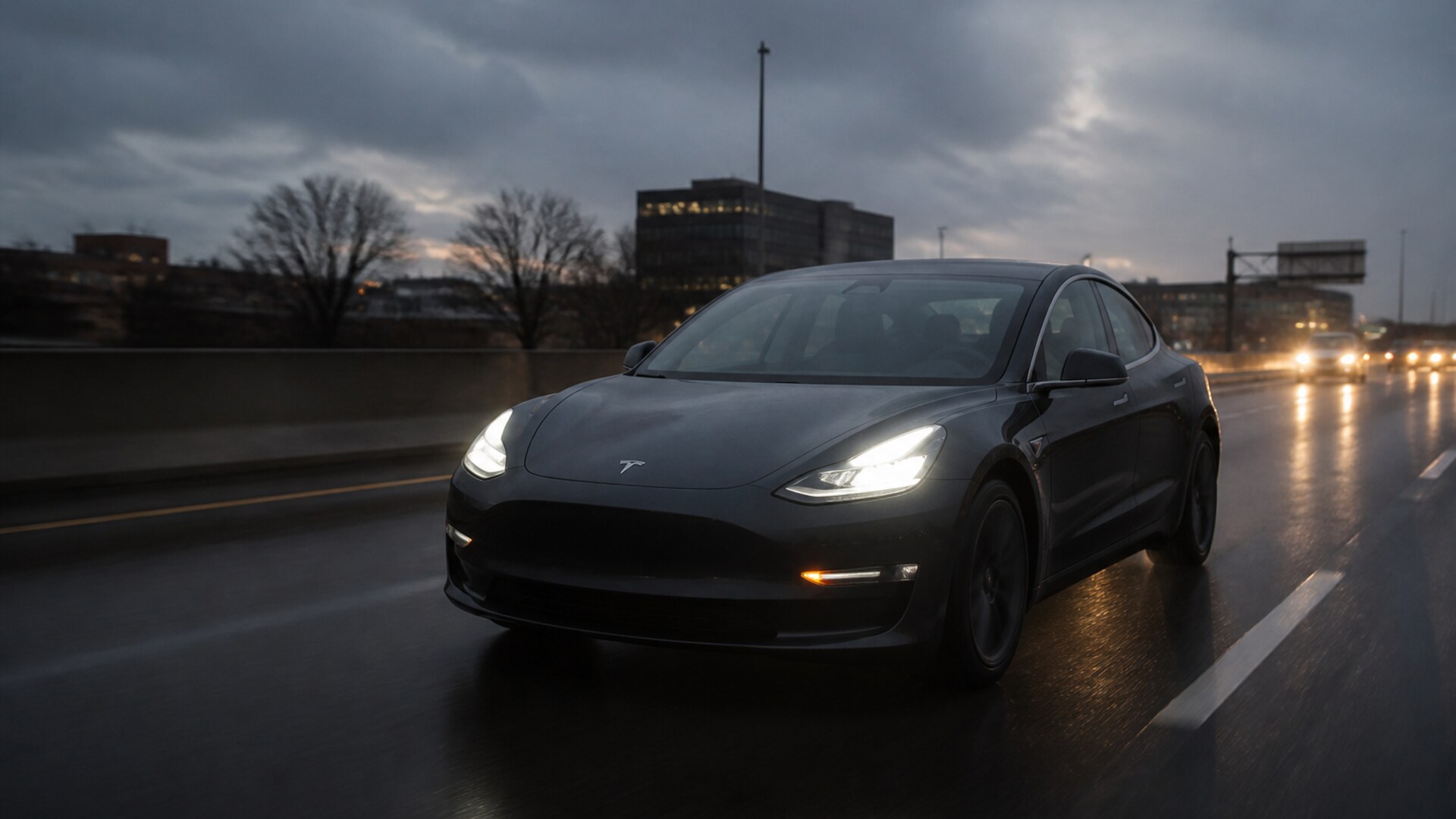 A dark Tesla on a wet highway