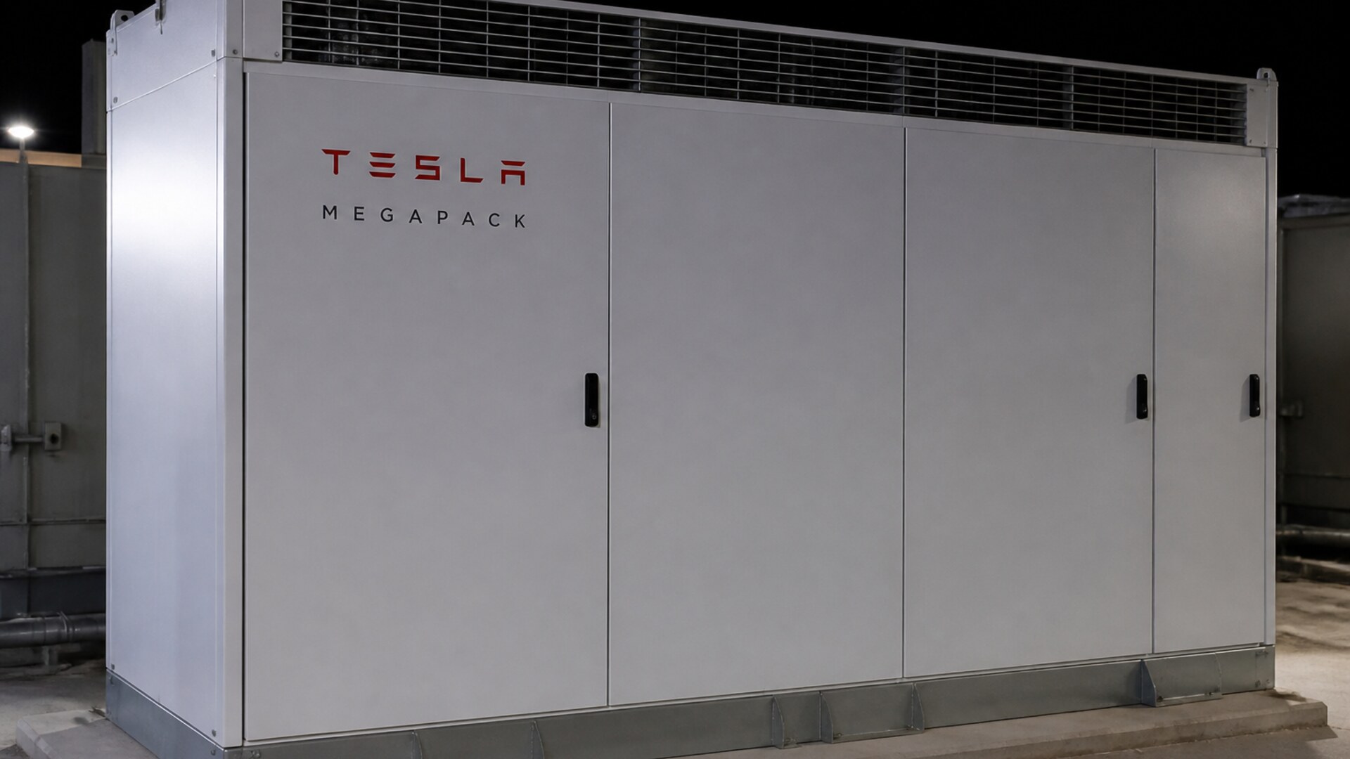A white Tesla Megapack at night