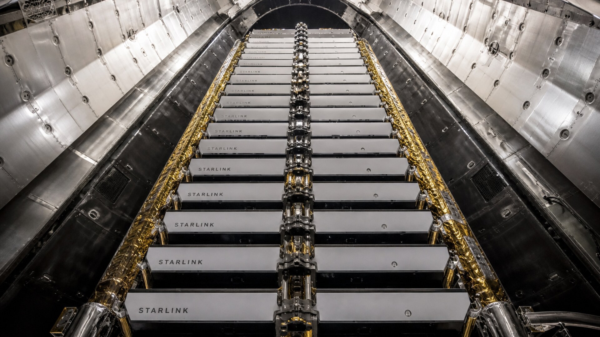 STARLINK-lettered satellites stacked in a rocket bay